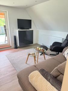 a living room with a couch and a flat screen tv at Ferienwohnung Haus Grenzwald in Nettetal
