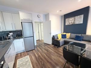 a living room with a couch and a kitchen at Harvey Apartments in Derry Londonderry