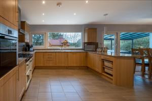 a large kitchen with wooden cabinets and a large window at The Fairways House in Glenrothes