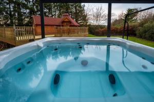 a hot tub in a backyard with a log cabin at The Fairways House in Glenrothes