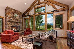 a living room with a stone fireplace and red furniture at Abode at Teton Manor in Jackson