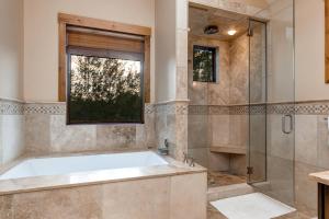 a bathroom with a tub and a glass shower at Abode at Teton Manor in Jackson +42 photos