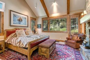 a bedroom with a bed and a chair and windows at Abode at Two Wolves in Teton Village