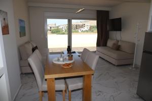 a dining table and chairs in a living room at Holiday Luxury Villas in Kalamaki