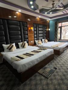 two beds in a hotel room with two bedsvisor at Hotel Shuhrah-I-Afaq - Near Srinagar Airport in Baghwānpur +35 photos