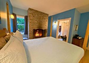 a bedroom with a large bed and a fireplace at The Edenwild Boutique Inn in Lopez