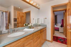 a bathroom with two sinks and a large mirror at Abode at Golden Spruce in Wilson +47 photos