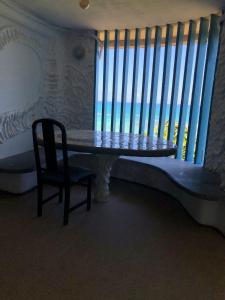 a table and a chair in a room with a window at Flor de Lótus Privilege in Japaratinga +13 photos