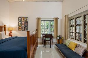 a bedroom with a bed and a couch and a window at The Anexure - Great Estate Stay for Remote Work in Siddapur