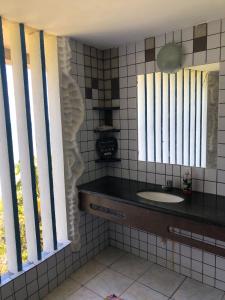 a bathroom with a sink and two windows at Flor de Lótus Privilege in Japaratinga