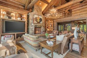 a living room with a stone fireplace and a television at Abode at Teton Game in Wilson