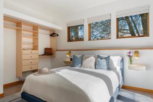 a bedroom with a bed with blue pillows and windows at Abode at Alpenglow in Wilson