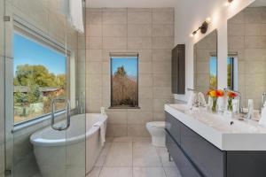 a bathroom with two sinks and a tub and a toilet at Abode at Alpenglow in Wilson +36 photos