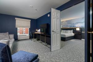 a room with a bedroom with a bed and a desk at The Ohioan Hotel and Event Center in Lewis Center