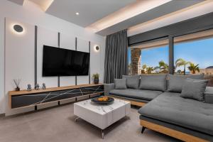 a living room with a couch and a tv at Luxury Villa Amani Retreat in Lindos
