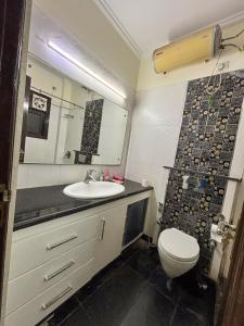 a bathroom with a sink and a toilet and a mirror at Sparra Homes in Gurgaon +31 photos