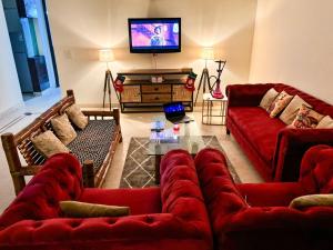 a living room with red couches and a flat screen tv at Sparra Homes in Gurgaon