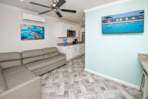 a living room with a couch and a ceiling fan at Blufin Bungalows & Marina in Chincoteague