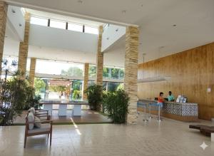 a lobby of a building with people sitting at a counter at Iloa Studio Alagoas conforto e encantamento in Barra de São Miguel