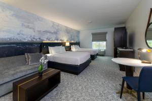 a hotel room with two beds and a couch at The Ohioan Hotel and Event Center in Lewis Center +17 photos