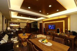 a restaurant with wooden tables and chairs and a television at Star Shine B&B in Jiaoxi