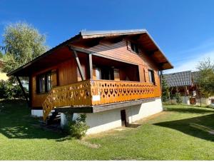 a small wooden house with a large balcony at Chalet les Colchiques in La Toussuire