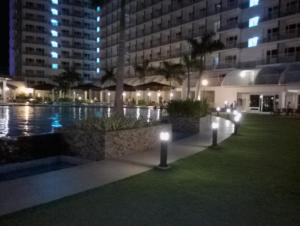 a courtyard at night with lights next to a building at Condo At Shell Residences in Manila