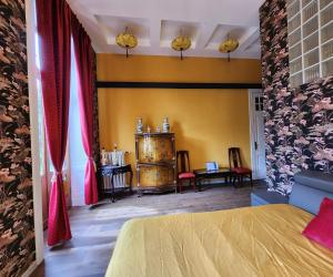 a bedroom with yellow walls and red curtains at Kasteel Rosmeulen in Mall