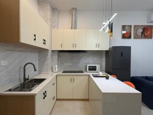 a kitchen with white cabinets and a sink at Xiaos Henderson Hotel in Lungga