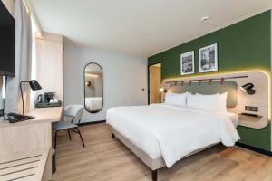 a bedroom with a white bed and a green wall at Campanile PRIME - Dijon Centre Gare in Dijon +49 photos