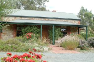 a brick house with flowers in front of it at Amanda's Cottage 1899 in McLaren Vale