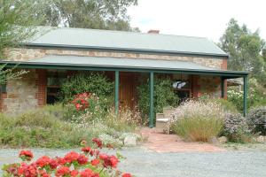 ein Backsteinhaus mit Blumen davor in der Unterkunft Amanda's Cottage 1899 in McLaren Vale