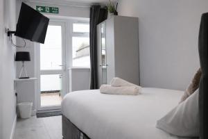 a bedroom with a white bed and a window at Walton Suites in Watford
