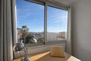 a room with a large window with a desk and a lamp at Etrave in Toulon