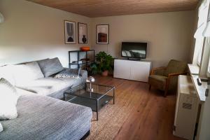 a living room with a couch and a tv at Bungalow Friedrich in Thale
