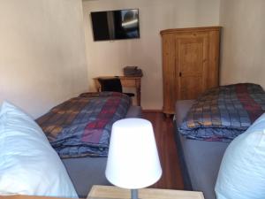 a room with two beds and a table with a lamp at Chalet Hoamad im Bayerischen Wald in Eschlkam +21 photos