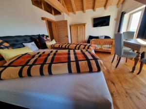 two beds in a room with a table and a desk at Chalet Hoamad im Bayerischen Wald in Eschlkam