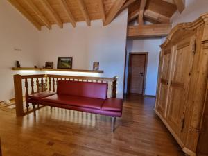 a red couch in a room with a wooden floor at Chalet Hoamad im Bayerischen Wald in Eschlkam