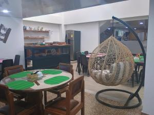 a room with tables and chairs and a net swing at HOTEL GANADERO in La Dorada