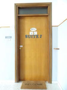 a wooden door with a smile sign on it at Suite seven &Home Restaurant in Paglieta
