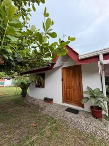 a house with a wooden door and some plants at Casa Osa Azul in Puerto Jiménez