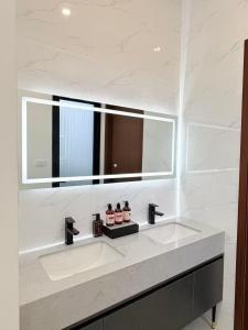 a white bathroom with a sink and a mirror at Xiaos Henderson Hotel in Lungga +38 photos