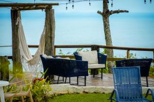 a deck with chairs and a table and a tree at VELINN Pousada 8 Ilhas in Ilhabela