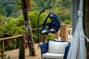 a chair on a porch with a swing at VELINN Pousada 8 Ilhas in Ilhabela