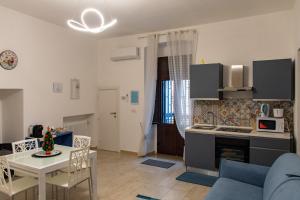 a kitchen and living room with a couch and a table at Rosa azzurra in Casamassima