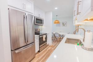 a kitchen with a stainless steel refrigerator at Breezy Beachside Views! Heated Pool & Pickleball! in Holmes Beach