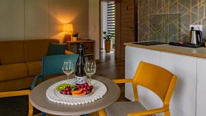 ein Tisch mit einem Teller Obst und Weingläsern in der Unterkunft Villa7 Balaton in Alsóörs