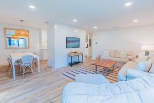 a living room with a couch and a table at Breezy Beachside Views! Heated Pool & Pickleball! in Holmes Beach
