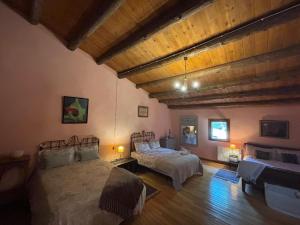 a bedroom with two beds and a wooden ceiling at Molino Santiago in Torre de las Arcas
