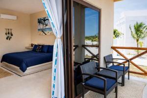 a bedroom with a bed and chairs and a balcony at Atenea - Optional Beach Club in Holbox Island +82 photos
